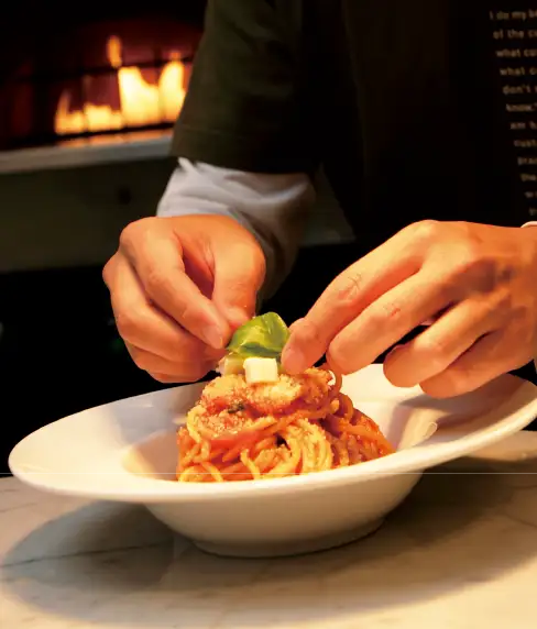 パスタを盛り付けるシェフの手元